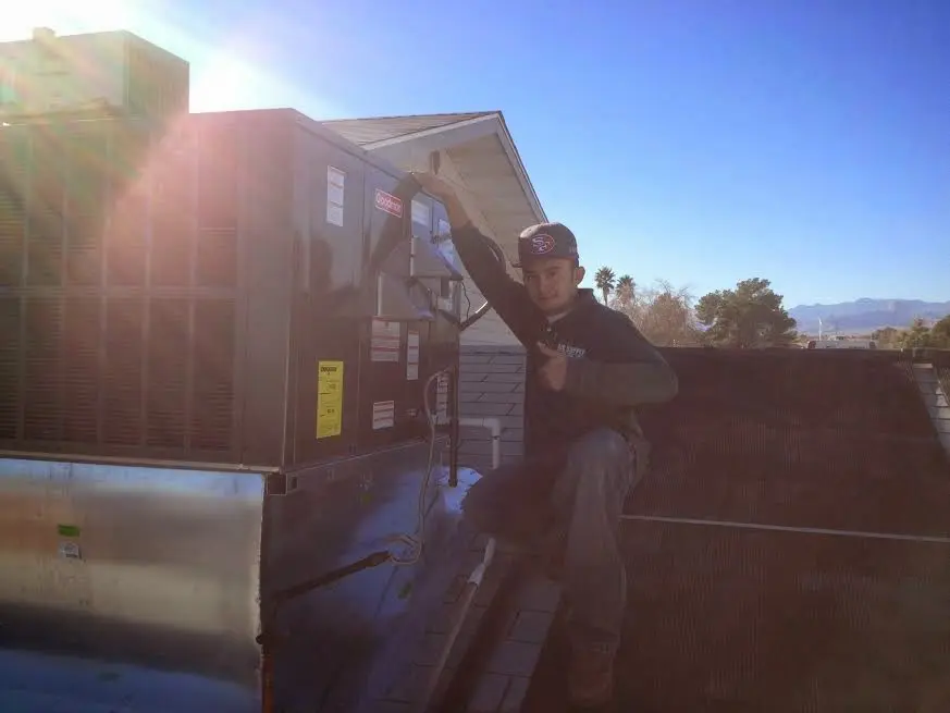 HVAC technician performing Heat Pump Repair on a rooftop unit in Nebraska City